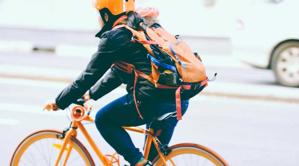 Chica en bicicleta con elementos reflectantes